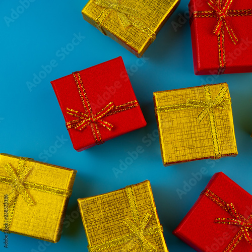 Holiday gold and red gift boxes on a blue background.