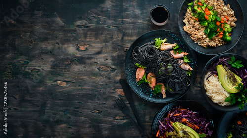 A set of food and dishes. Pasta, rice, risotto, salad. On a black background. Free copy space.