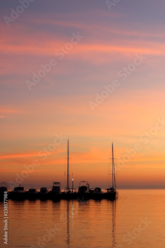 Boats in a harbor at sunset with beautiful colorful sky. © jelena990