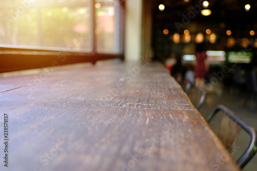 Wood table top with blur of people in coffee shop