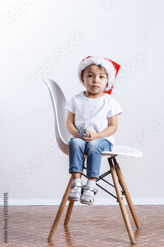 happy girl in santa hat with christmas candy cane standing on white background