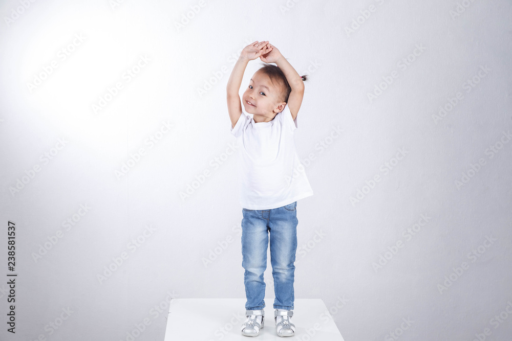Curious little girl is standing on a white background and posing. Curious little girl is standing on a white background and posing.