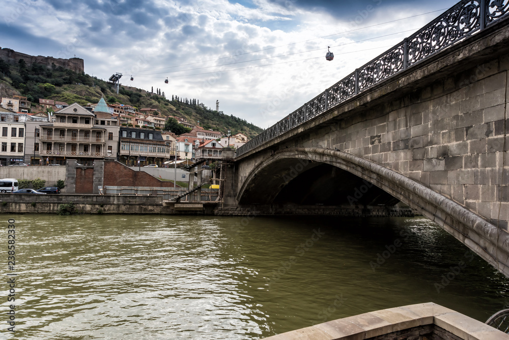 Naklejka premium Tbilisi, Georgia - July, 5, 2018. Metekhi bridge and Kura river