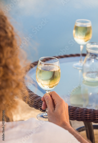 Obraz na płótnie Young man drinking white Portuguese wine by an outdoor table in Tavira, Algarve region, Portugal w salonie