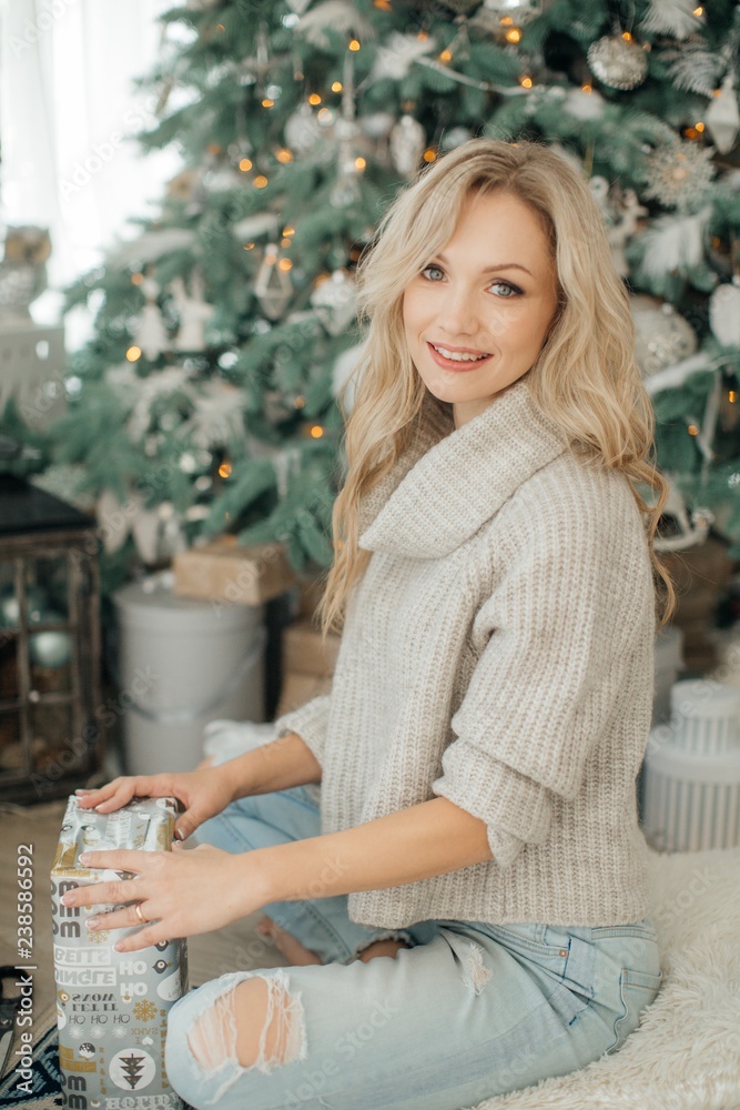 Happy blonde women in Christmas decorations with gifts