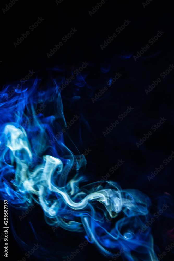 blurry smoke abstract background blue color on black night . free form swirl flowing fog in the air .