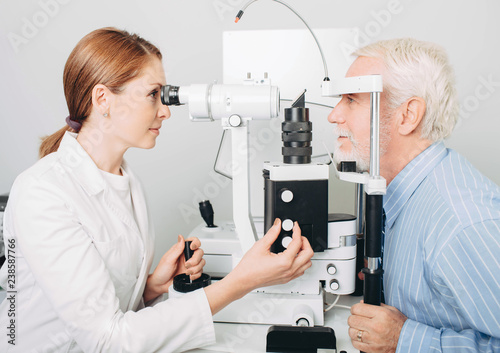 Senior patient checking vision with special eye equipment