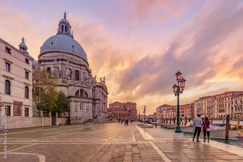 Tourists and street lamps at sunset close to the Basilica di Santa Maria della Salute in Venice.