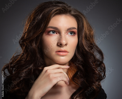Fashionable photo of a beautiful young woman with luxurious dark hair.