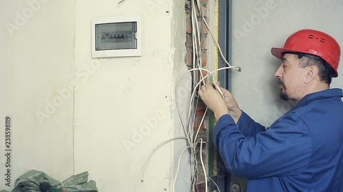 Man electrician performs installation work