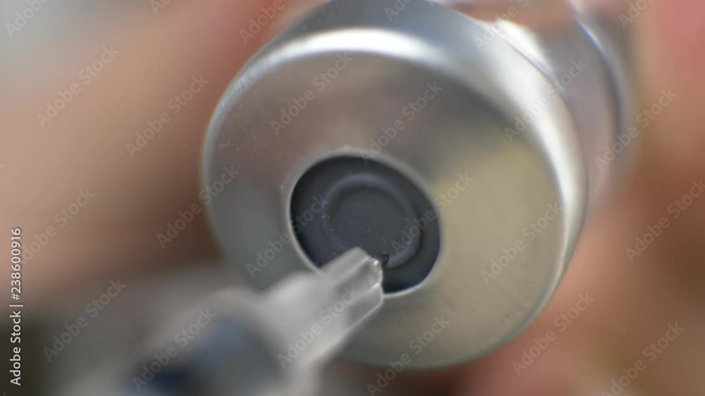 Vaccine in vial with syringe and needle in doctor's hand Vaccine in vial with syringe and needle in doctor's hand
