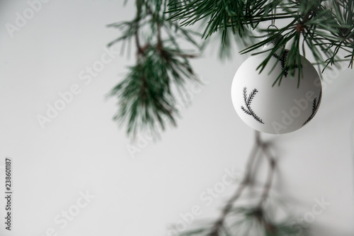 Christmas black and white toy among fir branches