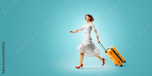 young beautiful woman arrived on vacation. She is Traveling very happy wallking with suitcase. color gradient background