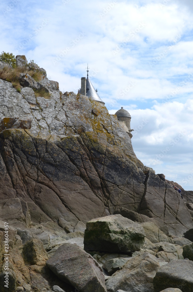 Fototapeta premium Rocks and top of a tower at Mont Saint Michel