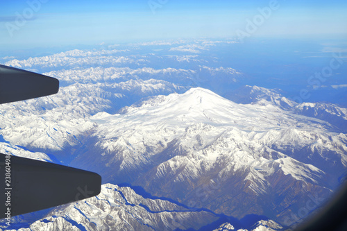 The view from the window of an airplane over the mountains of the Caucasus