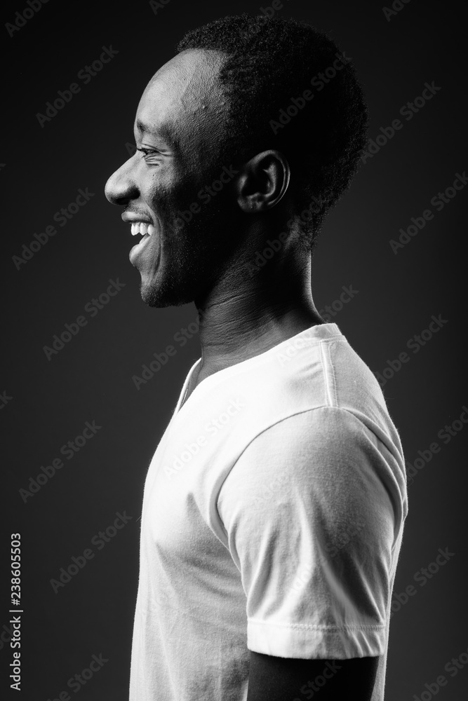Profile view portrait of young African man smiling in black and white