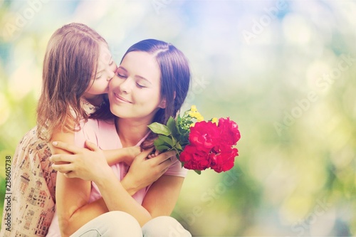 Young woman with little girl and beautiful flowers outdoors © BillionPhotos.com