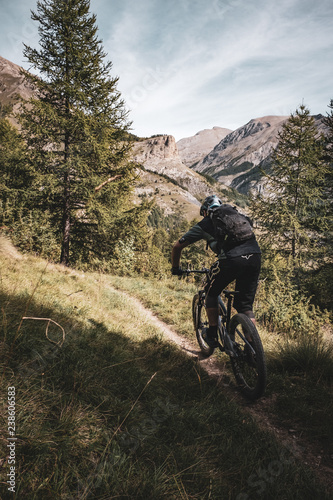 mountain biker riding fast towards the mountains in the alps