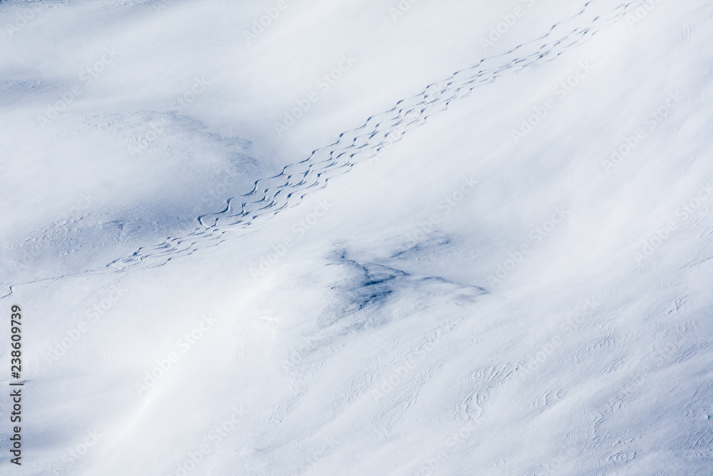 Weisser Tiefschnee mit Schispuren im Hochgebirge Weisser Tiefschnee mit Schispuren im Hochgebirge