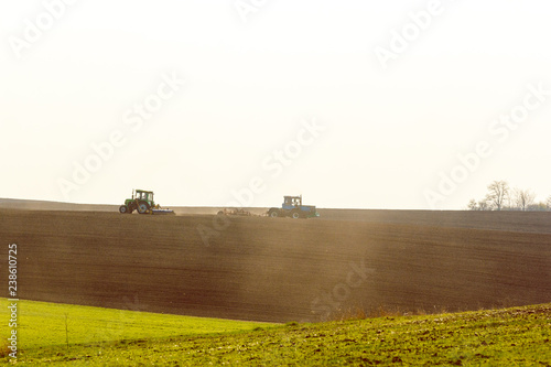 Tractor cultivating field at spring