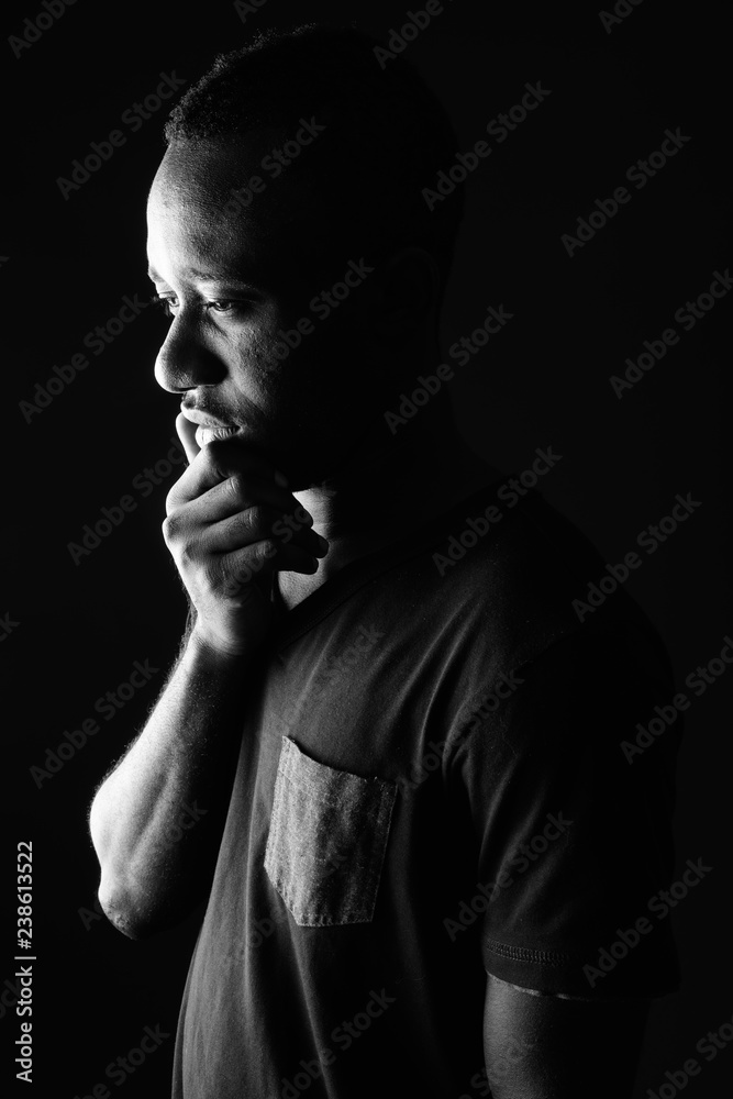 Sad young African man profile view thinking in black and white Sad young African man profile view thinking in black and white