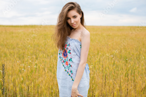 Portrait of a young girl on a background of golden wheat field