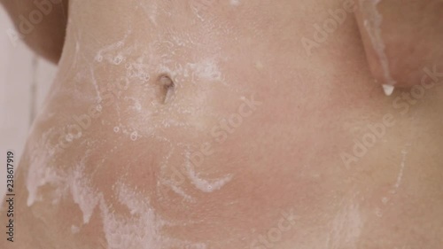 A woman's hand rubs her belly. In the image you see only the hand, the foam and the belly