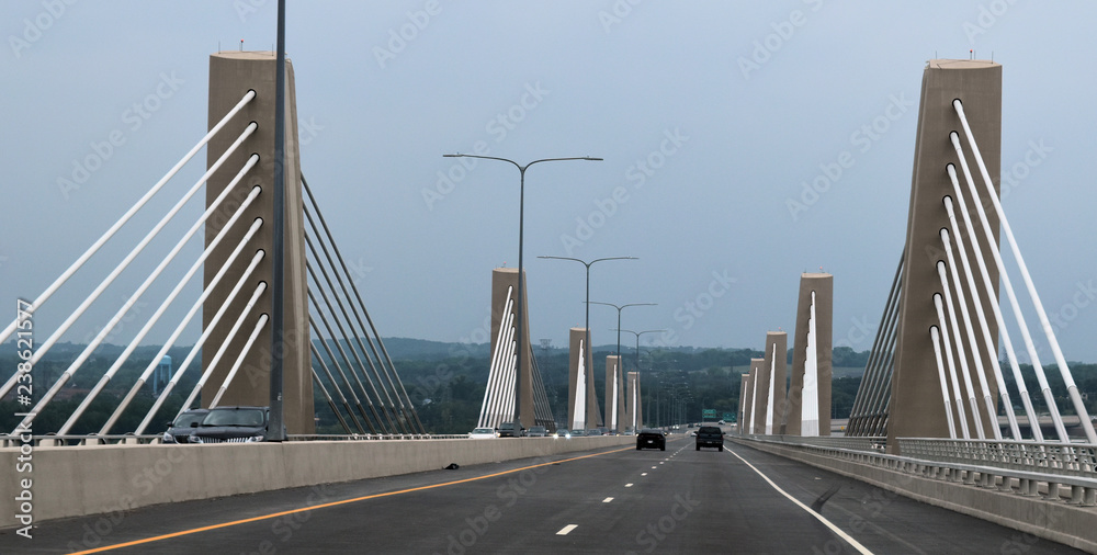 Fototapeta premium concrete suspension bridge with white parallel cables - road view