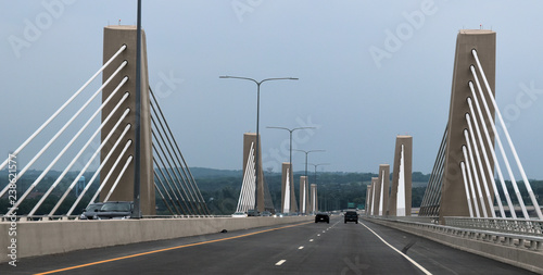 concrete suspension bridge with white parallel cables - road view