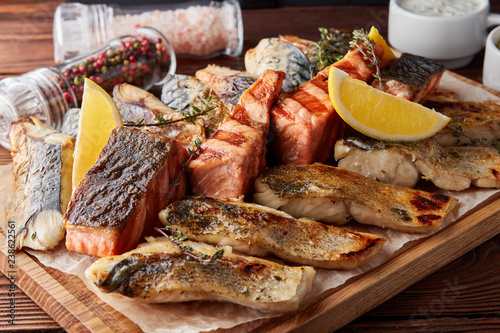 Assorted grilled fish on wooden board