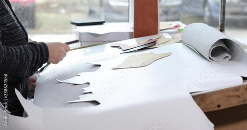 Shoemaker master cutting shoe leather as template, clicking the upper in a shoes factory.4k