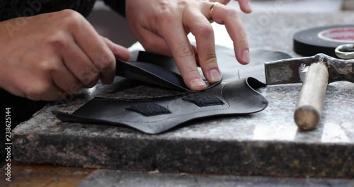 Shoemaker master cutting shoe leather as template, clicking the upper in a shoes factory.4k