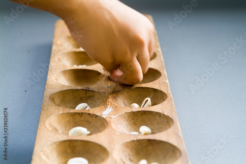 girls took shells from the holes in the congklak game photo