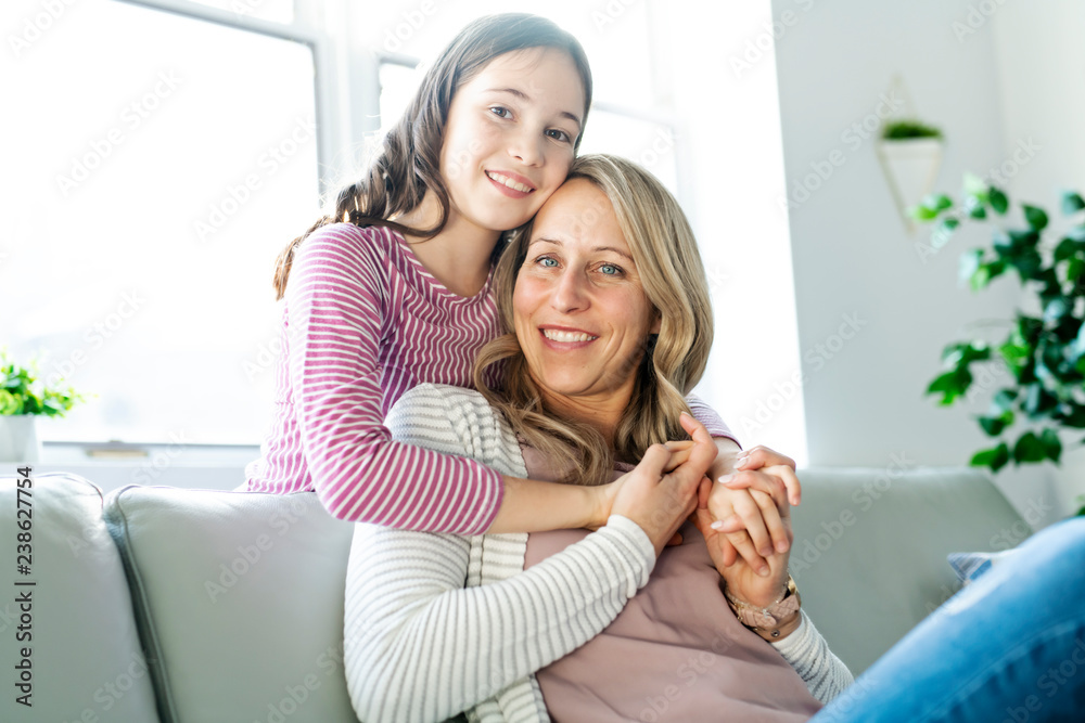 A Portrait of a beautiful mother and her little girl sitting at home and sharing a happy moment together. A Portrait of a beautiful mother and her little girl sitting at home and sharing a happy moment together.