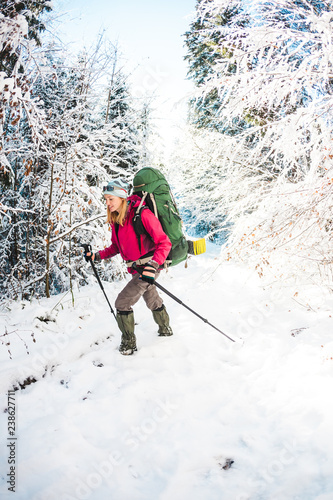 Woman with backpack and snowshoes in the winter mountains.