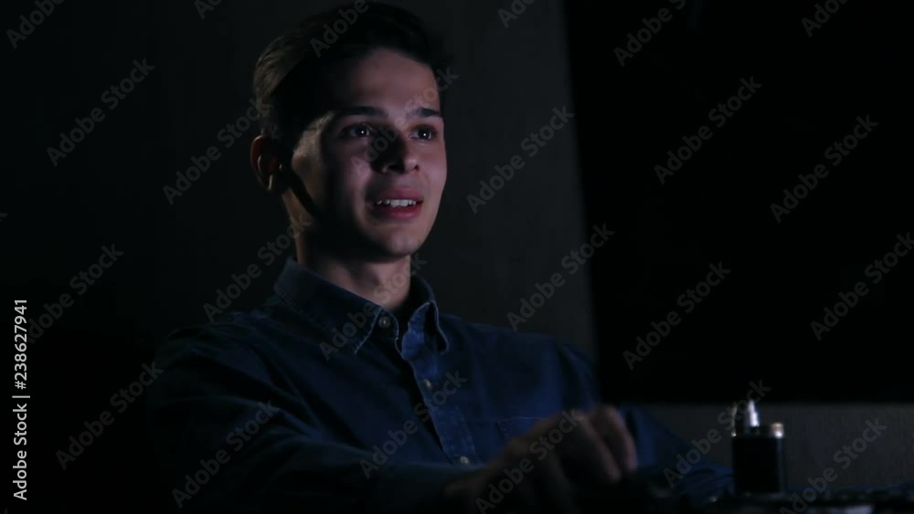laughing young man surfing the net on computer at night laughing young man surfing the net on computer at night