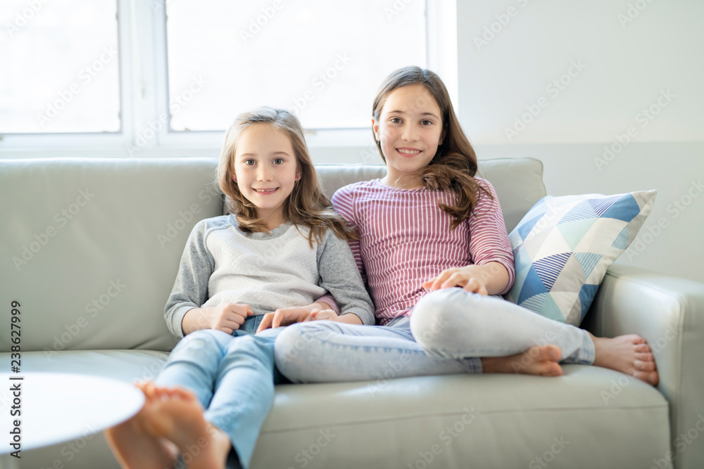 A Cute preschool sister girls on sofa or couch