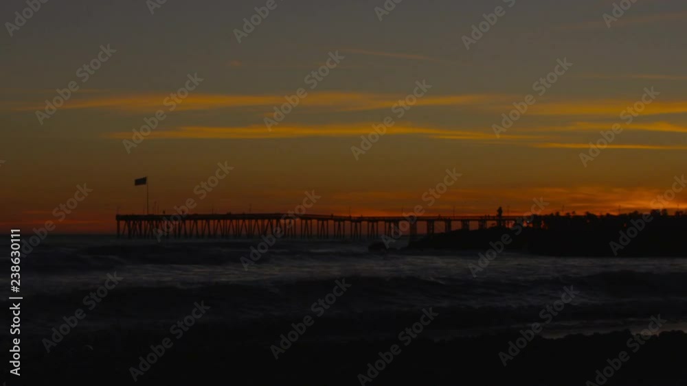 Pier silhouette at sunset and waves in slow motion Pier silhouette at sunset and waves in slow motion