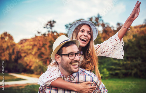 Meeting in the park. Boyfriend carrying his girlfriend on piggyback. Love, dating, romance photo