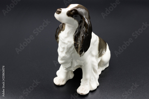 Antique porcelain figurine of a dog Spaniel breed on the black background