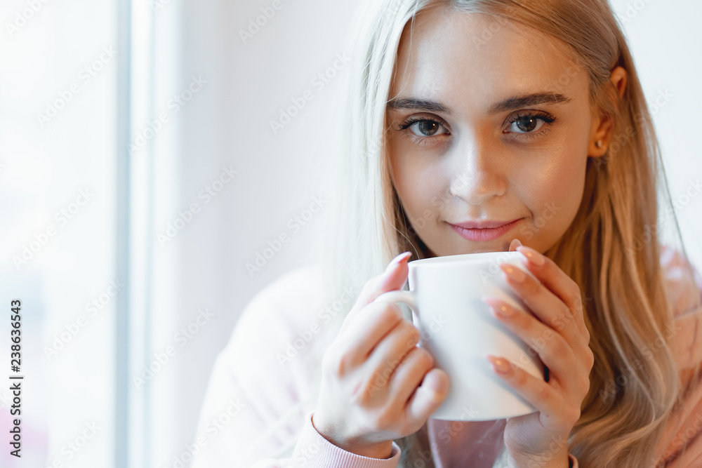 An elf alike, young girl enjoying a cup of coffee or milk while An elf alike, young girl enjoying a cup of coffee or milk while