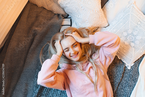 Smiling girl, with long blond hair, enjoying happiness while lyi photo