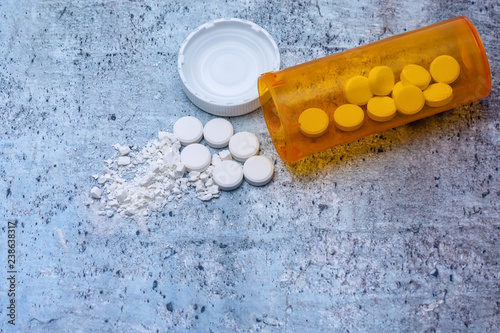 Opioid and drug addiction epidemic concept in America with pills, cap, and bottle and room for copy text