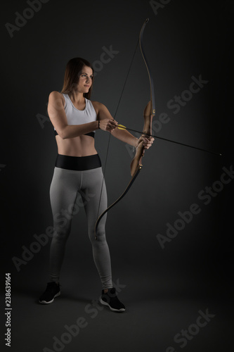 Young archer girl targeting with bow and arrow