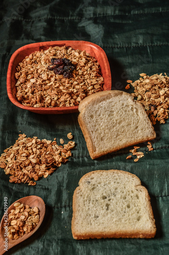plate with cereal granola and bread on green background