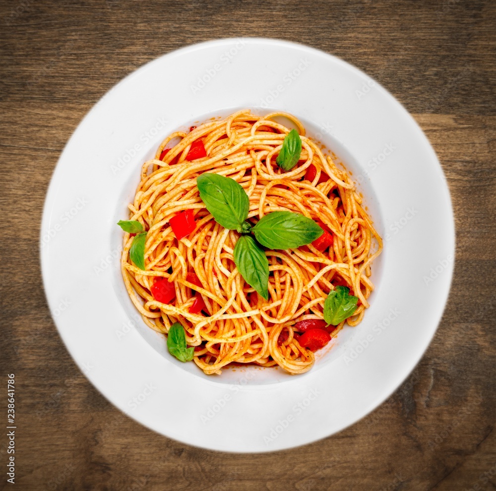 Spaghetti pasta with tomatoes and parsley on  table.