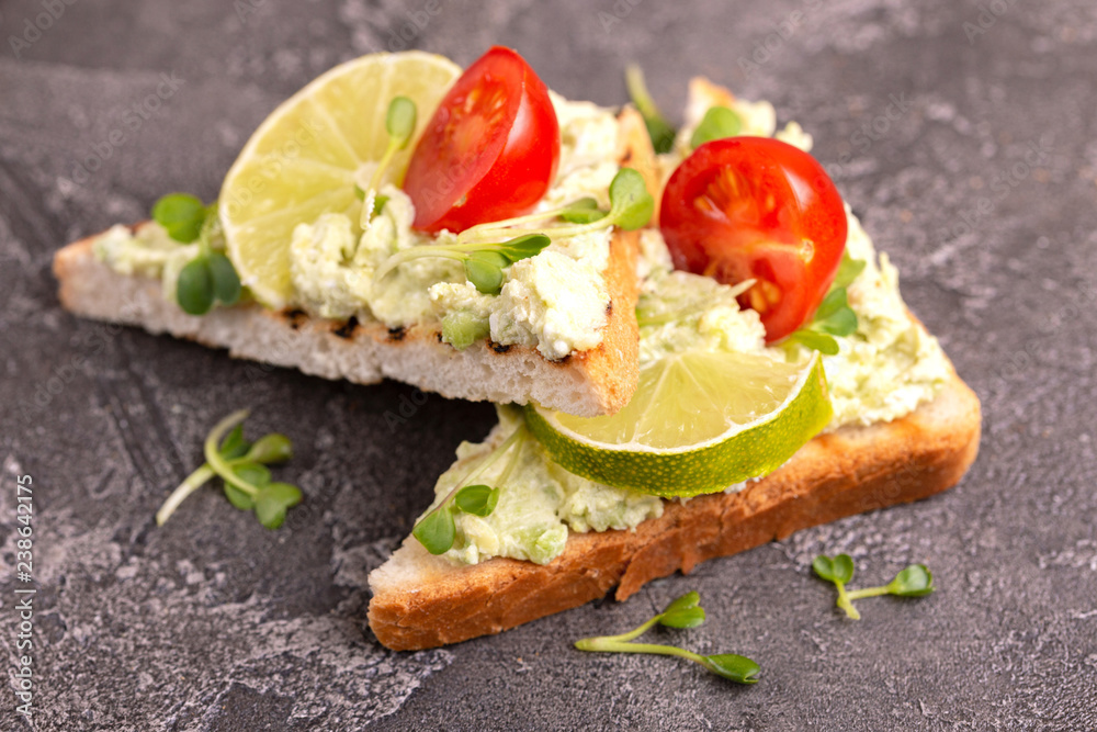 Toasts with avocado pate, fresh microgreen and cherry tomatoes