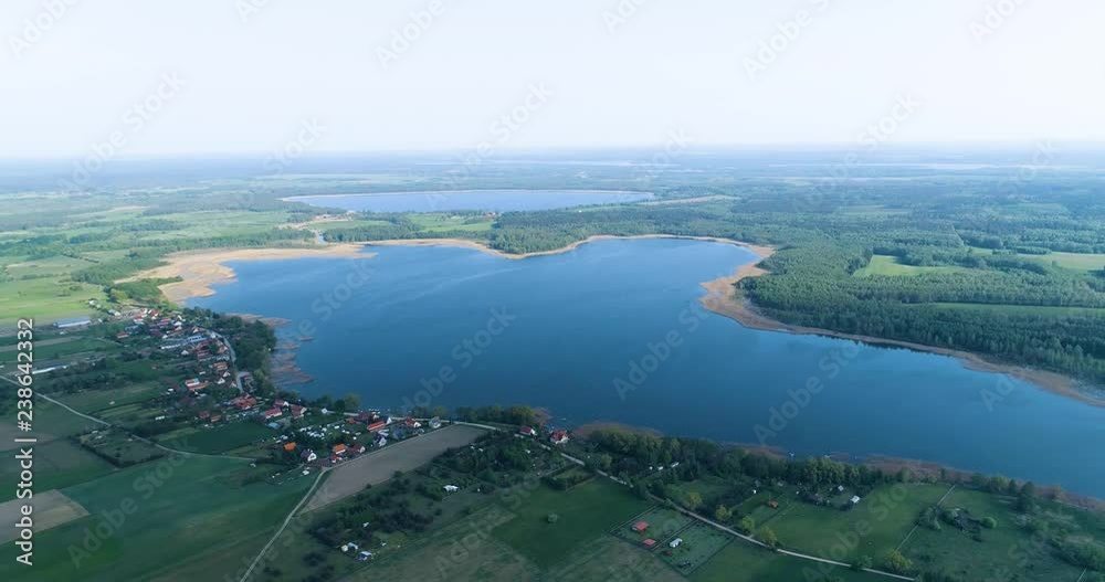 Smooth aerial shot of big lake surrounded by fields Smooth aerial shot of big lake surrounded by fields