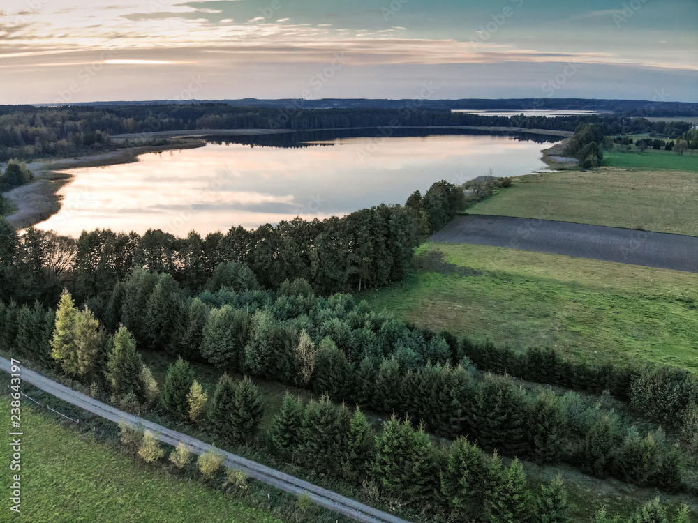 Aerial panorama of fields, plains lakes and forests over sunset sunrise
