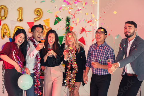 Group of Multiethnic Friends Celebrating Chrismas New Year Party , Enjoy Throwing and Blowing Confetti  Happy Time in Holiday